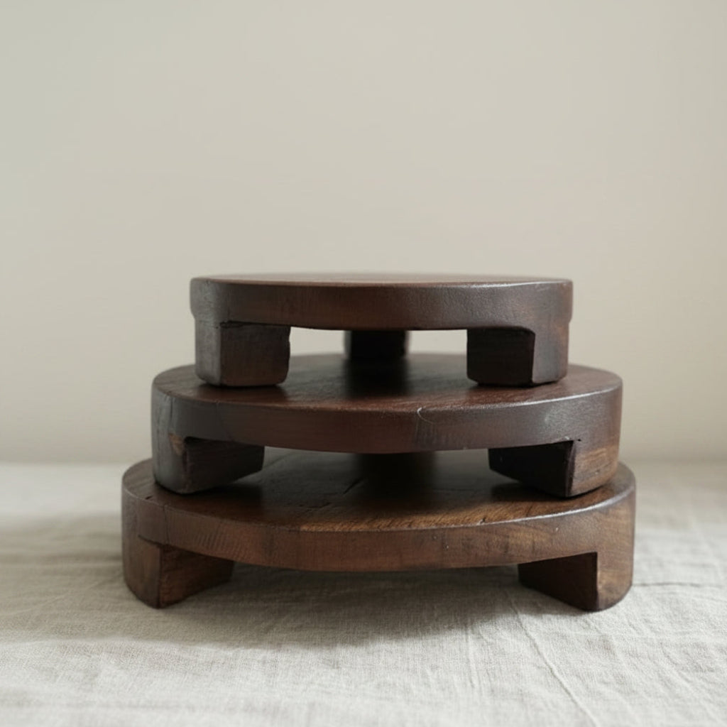 Wooden Round pedestals with a dark brown finish, displayed on a light beige linen runner in a kitchen.