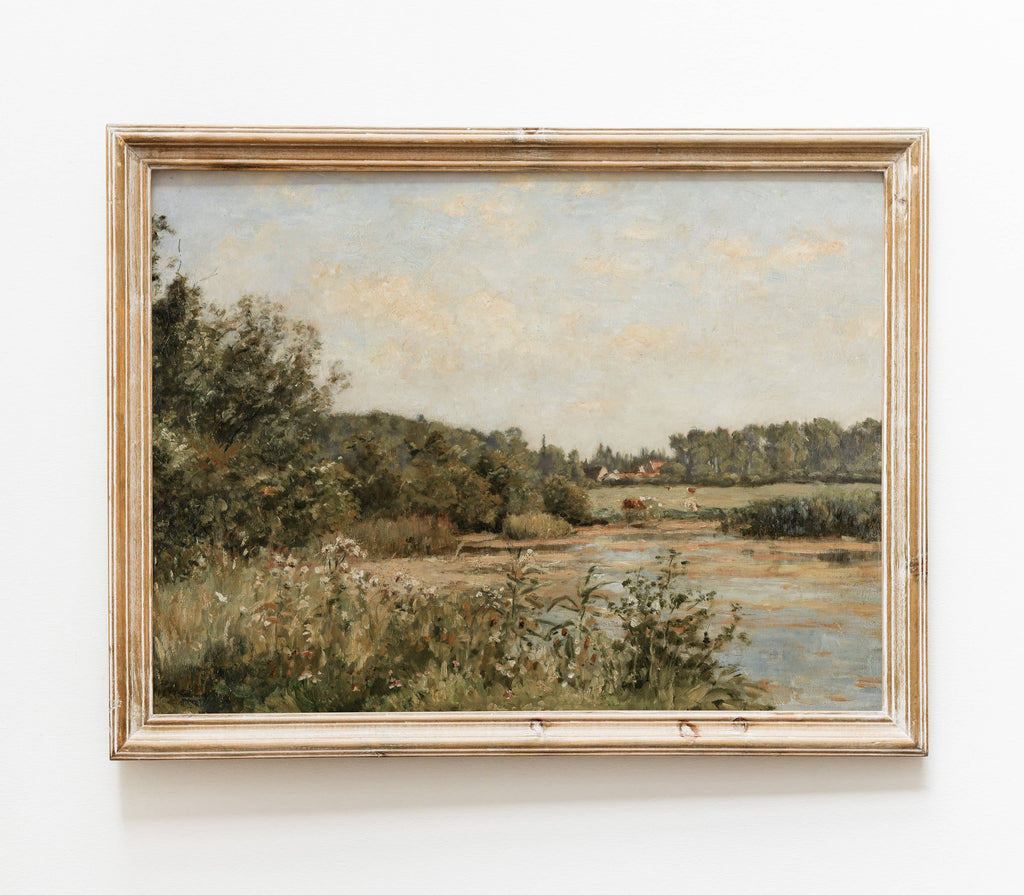Framed landscape painting of a river and trees on a white wall