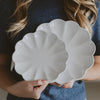 Person holding a white scalloped-edge serving trays