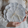 Person holding a white scalloped-edge servings trays with a bow