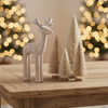 Wooden deer figurine on a coffee table with christmas decorations.