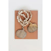 Wooden beads and decorative items on a brown card with a white background