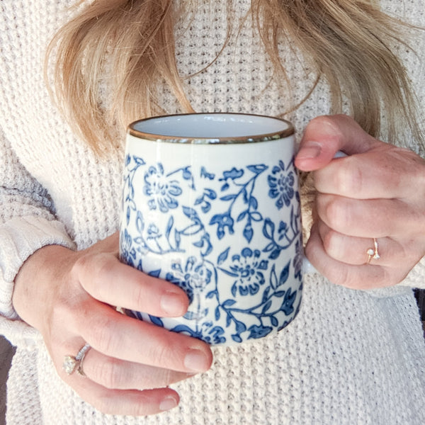 woman holding blue and white coffee mug